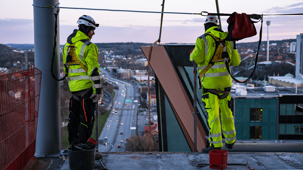 Två glas- och metallmontörer arbetar med installationen av fasadelementen till Kineum i Göteborg