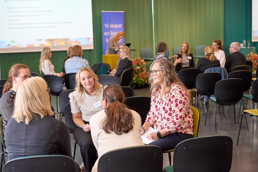 Konferensrum av kvinnor i mindre diskussionsgrupper 