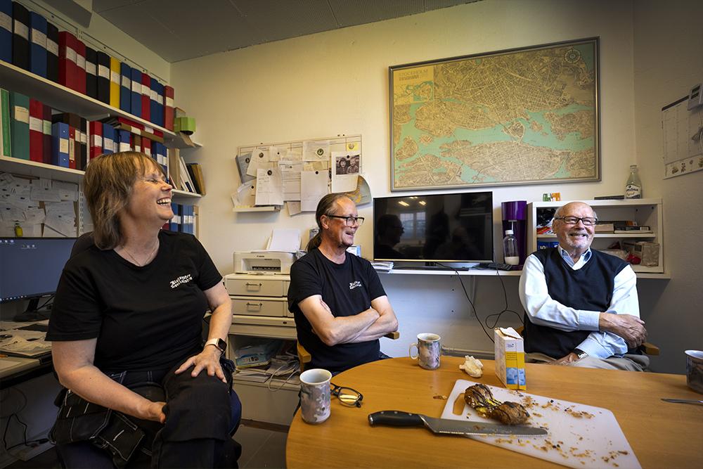 Rennée, Niclas och Hans Kuhn skrattar vid fika bordet