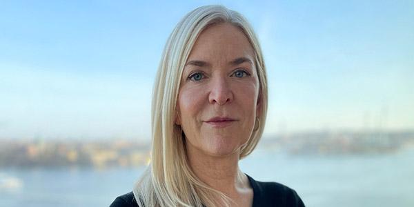 Kvinna med blont hår mot suddig bakgrund