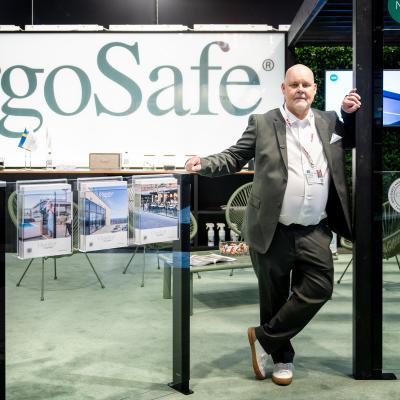 En man står vid två glaspartier, det står ErgoSafe i bakgrunden