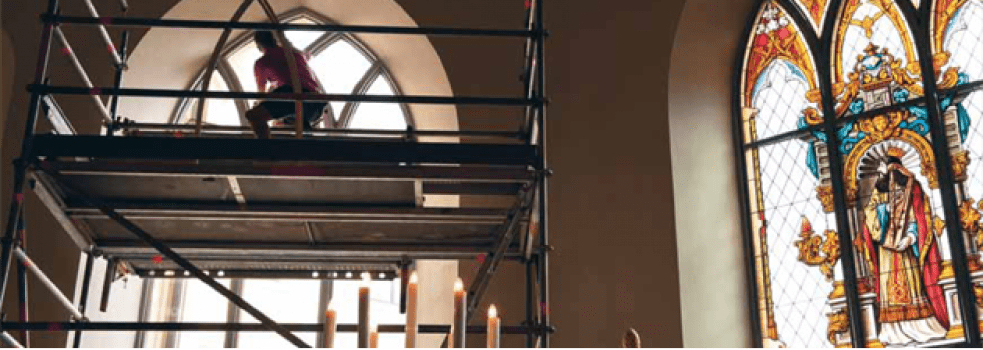 En glashantverkare arbetar på ett kyrkofönster