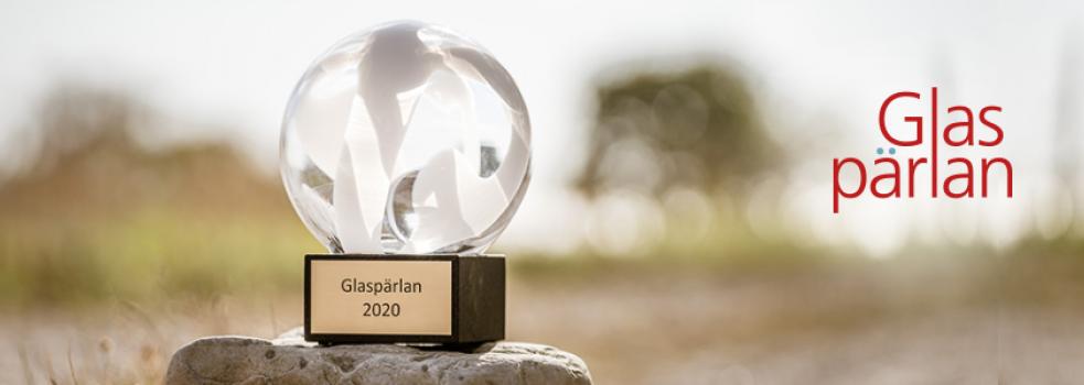 Priset Glaspärlan står på en sten med diffus bakgrund