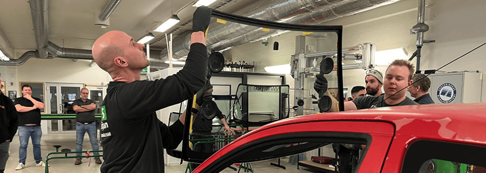 Två bilglastekniker monterar en vindruta