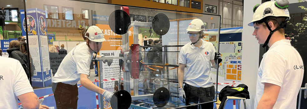 Tre killar monterar ett skjutglasparti på Yrkes-SM