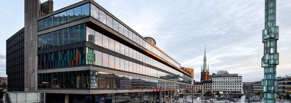 Glasfasad på hus och spårvagn