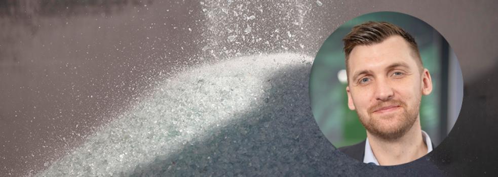 Krossat glas i bakgrunden, med en inklippt man framför