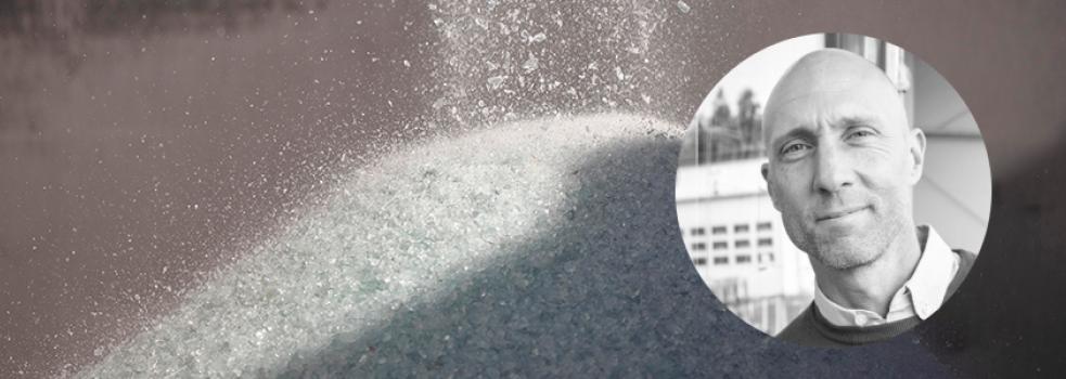 I bakgrunden syns krossat glas, framför en inklistrad bild på en man