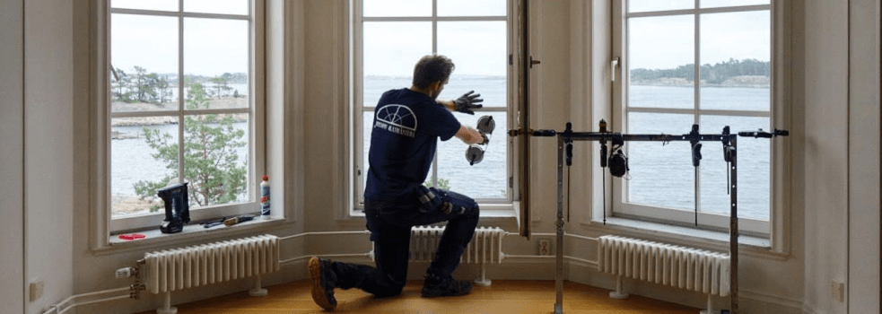 Glasmästare i arbete med fönster mot vattenutsikt