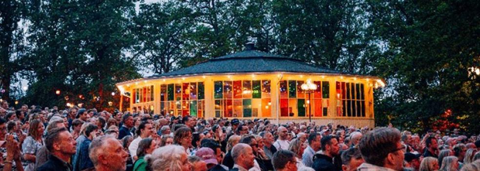 En byggnad med färgade glas i ett hav av människor.