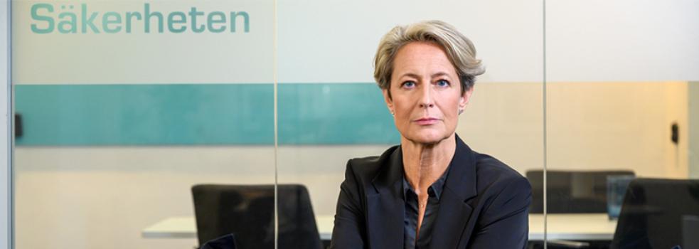 Kvinna i blont hår och kavaj tittar in i kameran