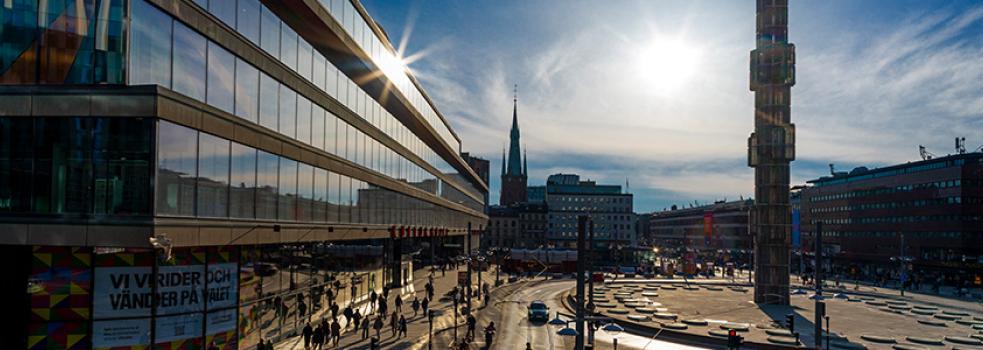 Överblick av torg med byggnad med stor glasfasad