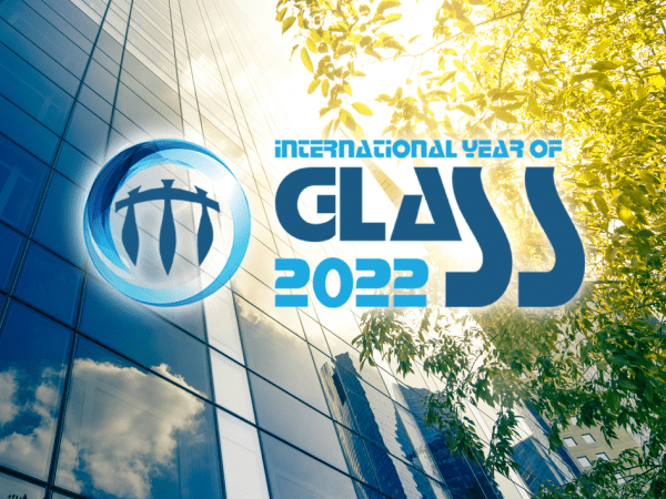 Logotypen för International year of glass visas i motljus framför en glasfasad och lövverk