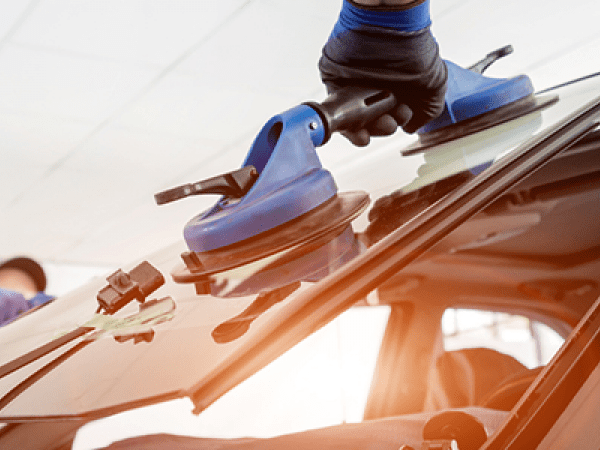 två personer monterar vindruta på bil