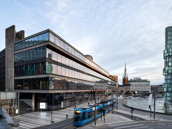 Glasfasad på hus och spårvagn