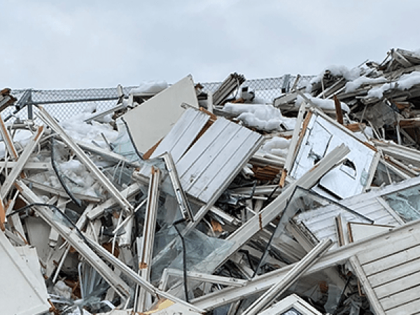 Hög av fönster och altandörrar på återvinningsstation