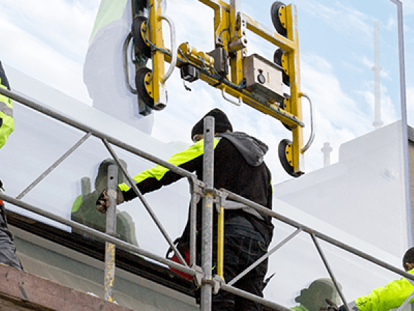 Personer monterar glas på fastighet