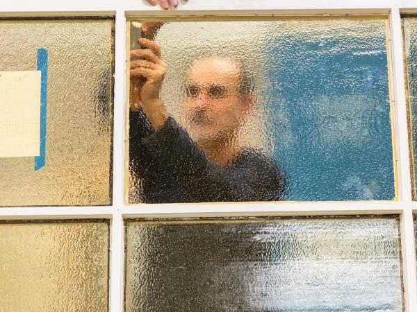 Ett fönster med en man bakom som syns blurrigt