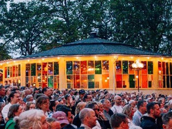 En byggnad med färgade glas i ett hav av människor.