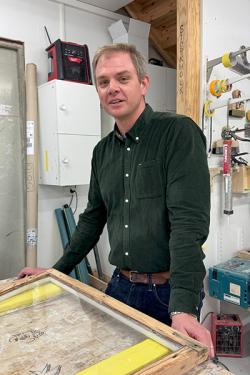 Man står vid ett fönster som ligger på ett bord