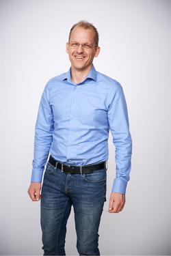 Man i skjorta och jeans mot vit bakgrund