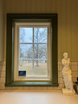 Bild på fönster med en skulptur bredvid.