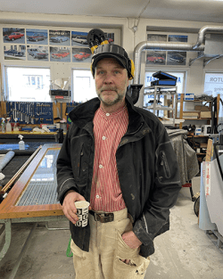 Håkan Sundberg yrkeslärare på Hushagsgymnasiet i jacka, randig skjorta och arbetsbyxor