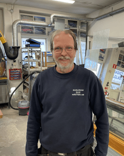 Ari Nordlund, glasmästare på Borlänge Glasmästeri, i blå tröja och glasögon